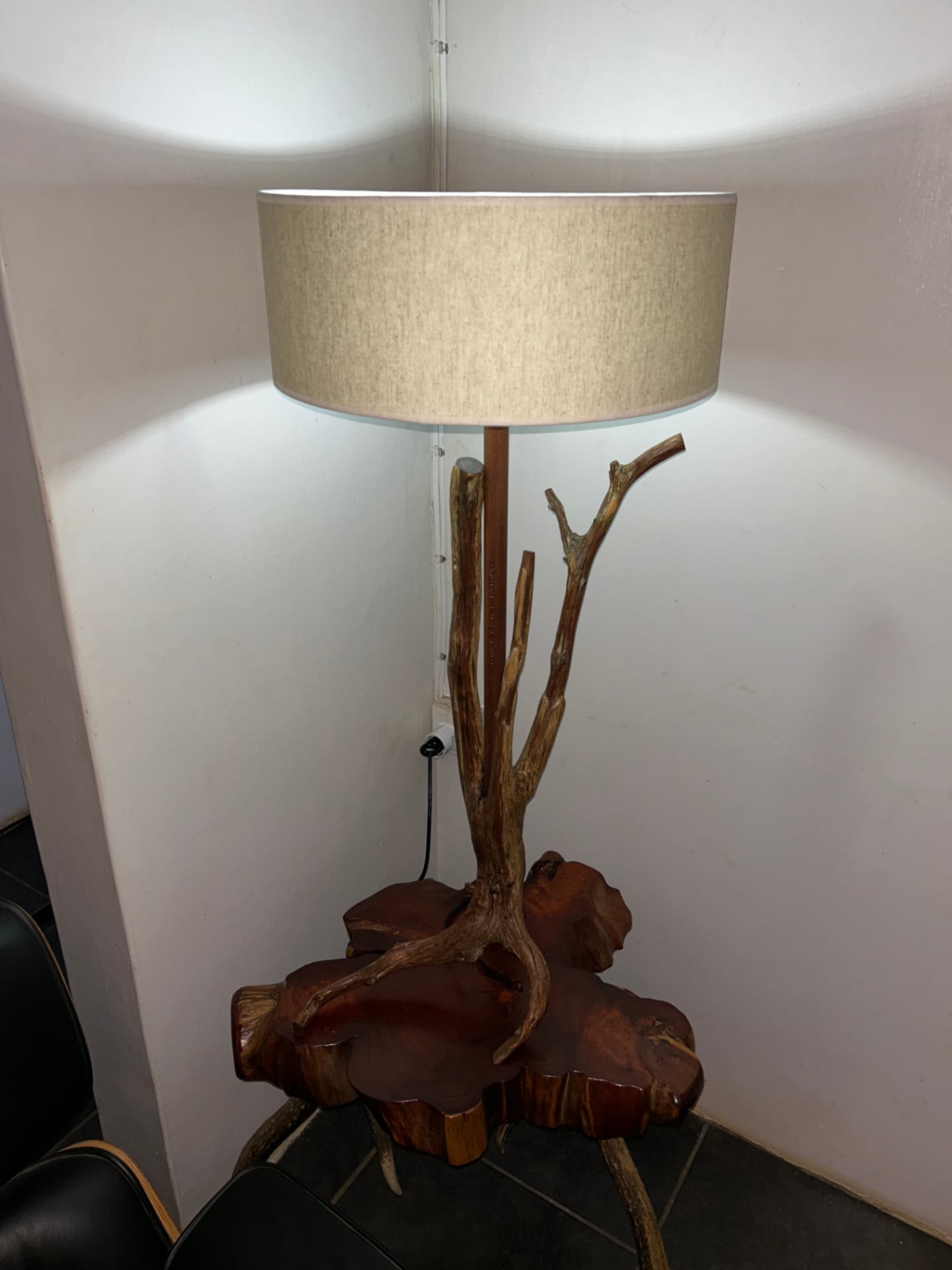 Branch table lamp resting on a carved wooden base