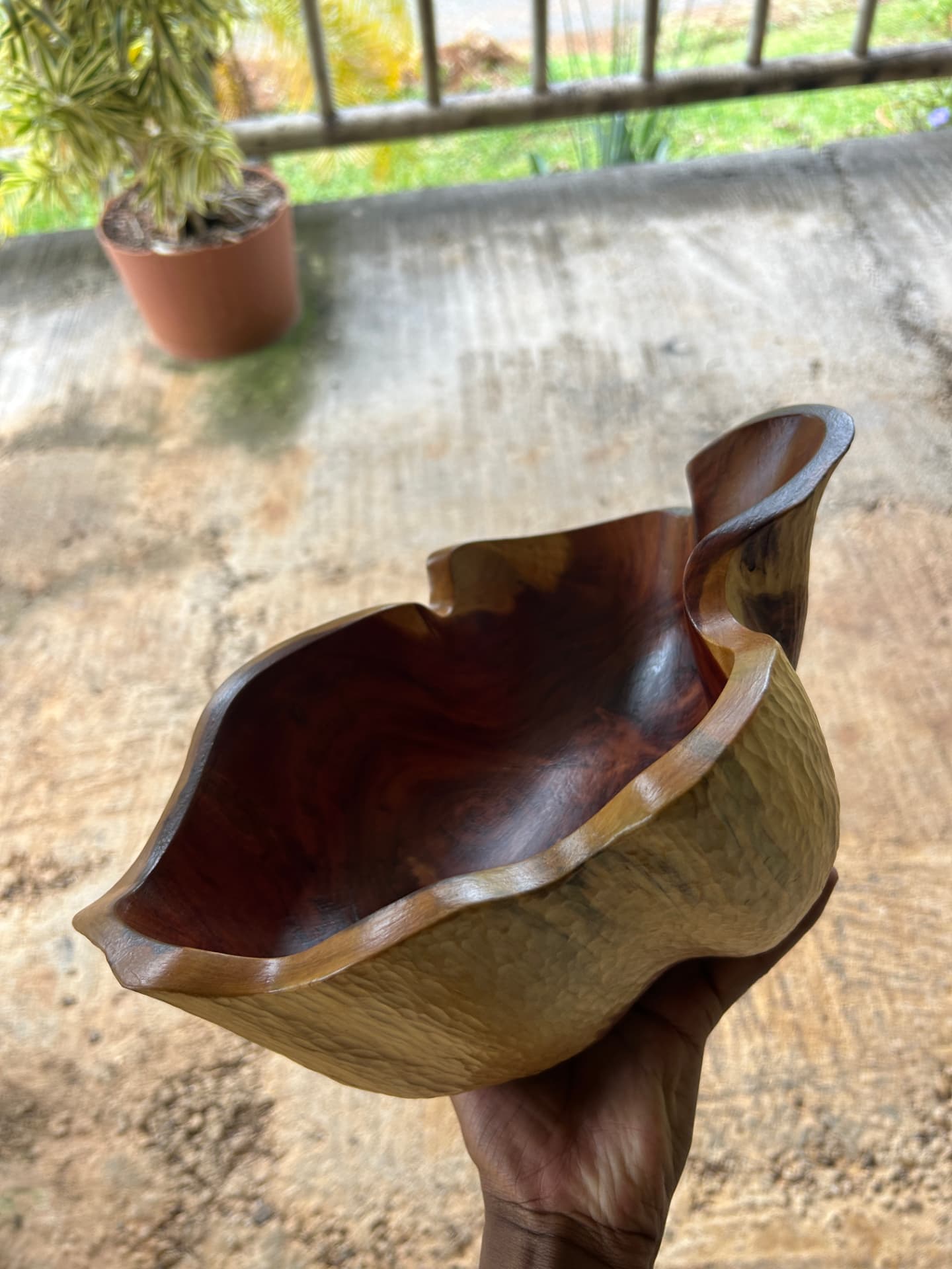 Hands holding a freshly carved wooden bowl